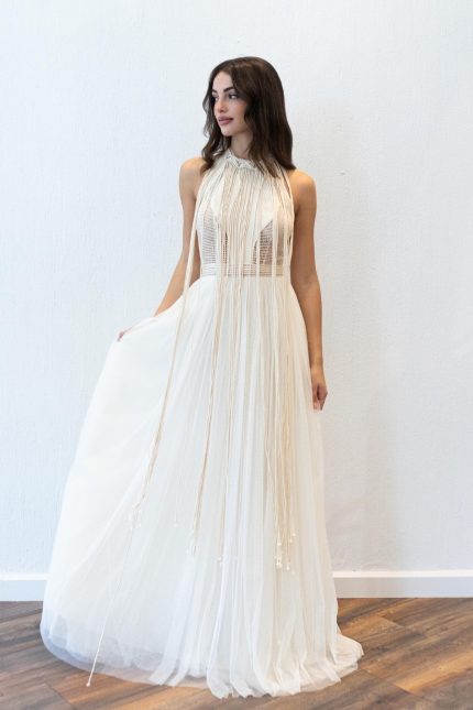 Model in the 'Eliana', a macrame halter wedding dress by Atelier Zolotas, featuring handmade cotton cords
