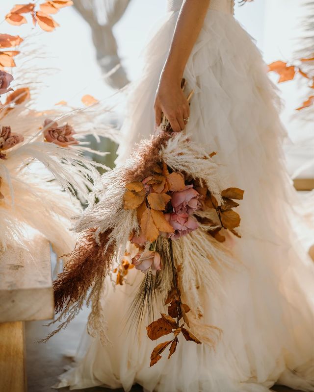 bridal shot of a handmade skirt scuplted in soft tulle by atelier zolotas, holding a boho-style bouquet