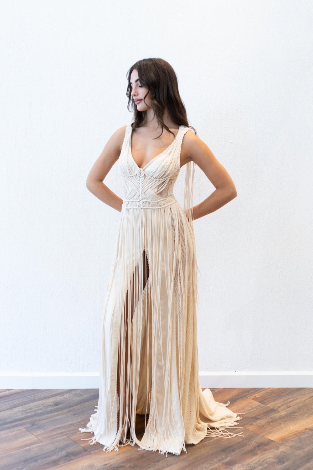 Model in the 'Isla' dress by Atelier Zolotas, a high slit macrame bridal dress with long cotton cord details