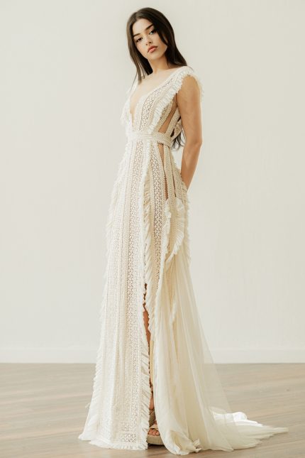 Bride wearing the Karly V-neck wedding dress by Atelier Zolotas with vintage lace, geometric trims, and removable semi-sheer sleeves in an open-back design